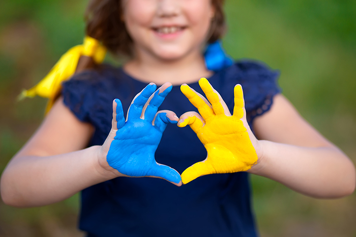 love for Ukraine concept - photo of young girl making heart hands