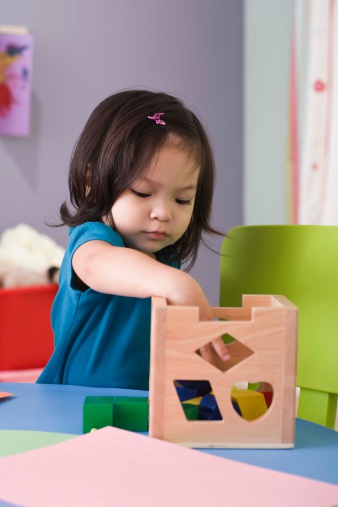 Girl playing with a wooden toy