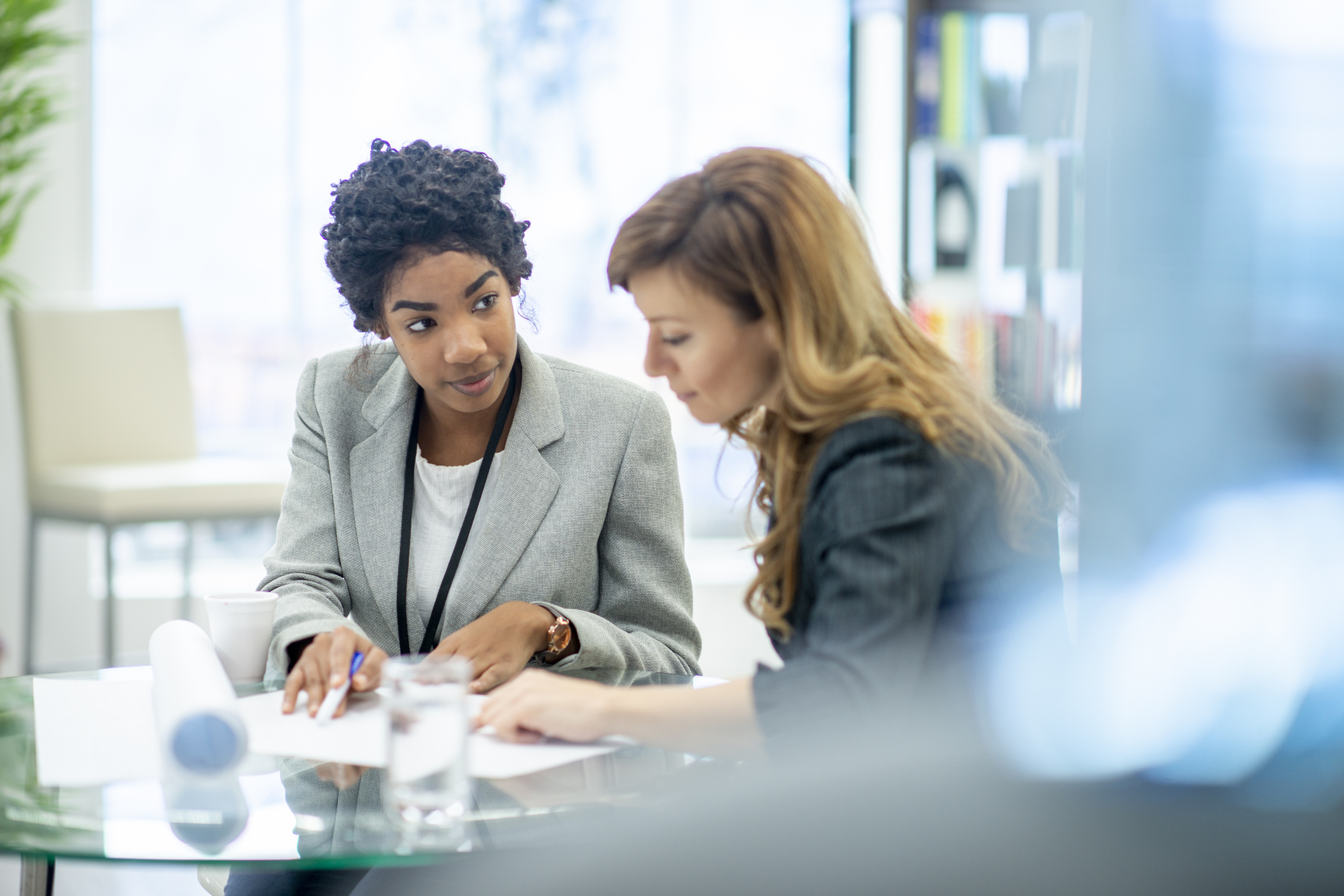 Two women working together at a desk.
