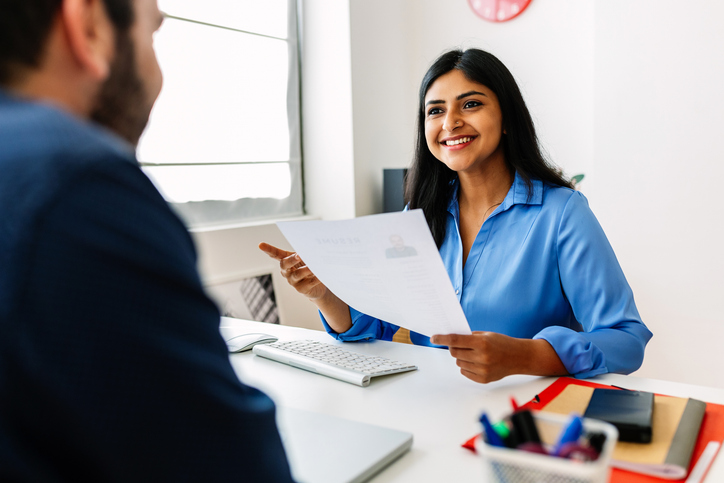 Friendly interview between female HR director and male job candidate.